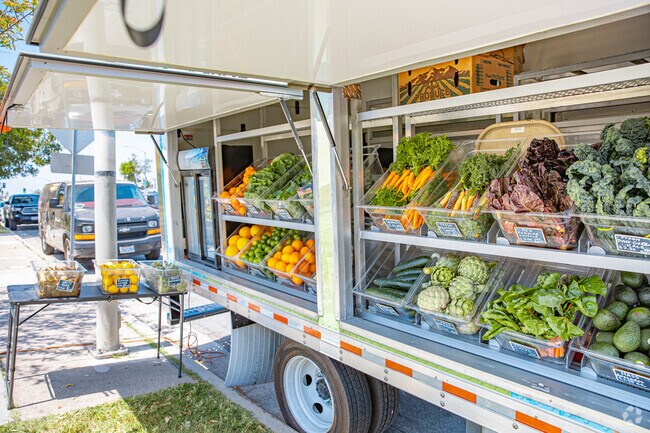 Vendors offer fresh produce from roadside stalls, drawing in neighborhood foot traffic.