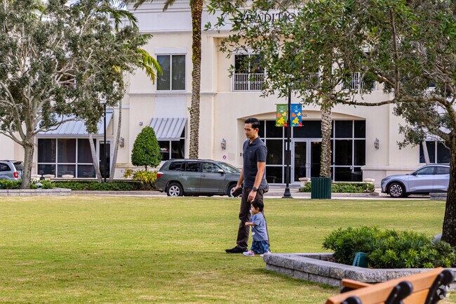 A father enjoying the greens space in the neighborhood with his toddler.