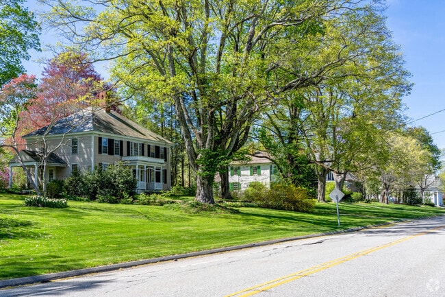 A row of historic homes in Hampton line the quiet main road in town with large trees and expansive yards.