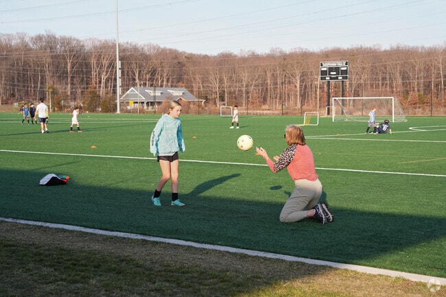 A parent assists with a soccer warmup at a local soccer field.