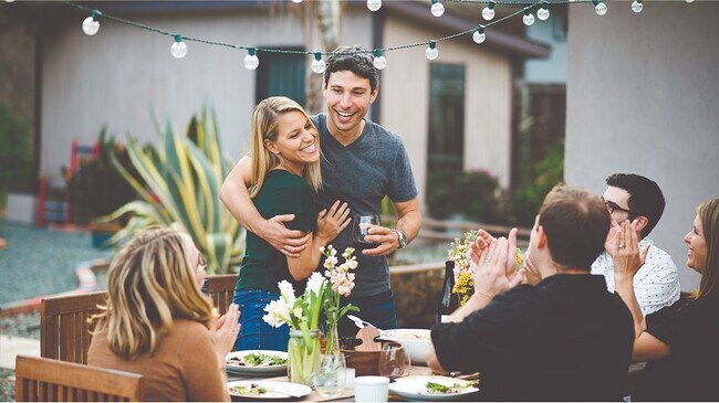 Couple hugging with friends at a table
