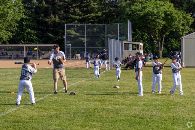 Sunset Park buzzes with energy as young players gear up for a baseball game.