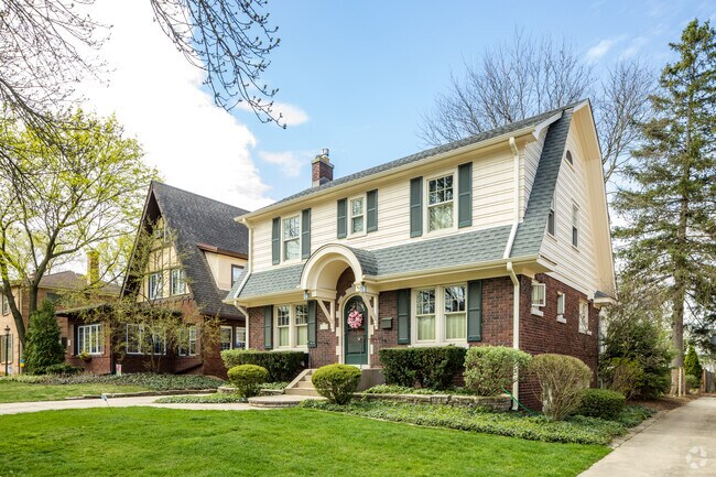 A colonial-style home with a distinctive curved roof stands out among other homes.