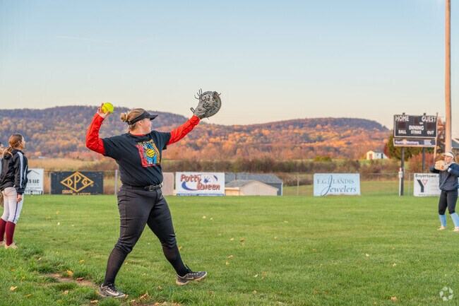 Local softball leagues warm up before a game under the lights at Douglass Township Park.