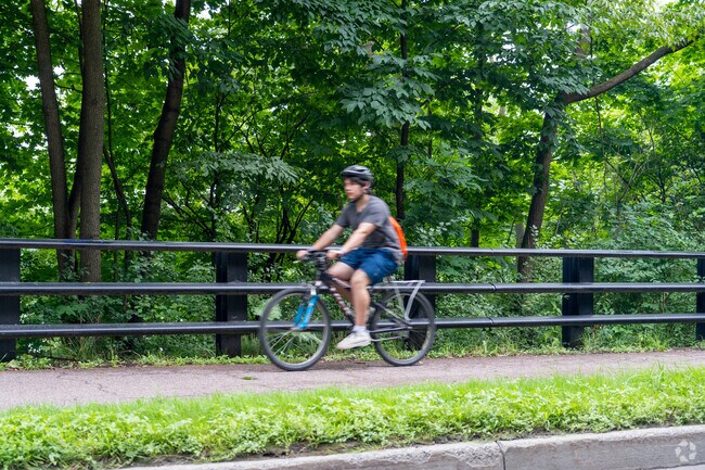 A person rides their bicycle along Winooski River Walk in Downtown Winooski.