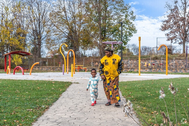 A family enjoys a peaceful stroll through the Cypress Spray Park.