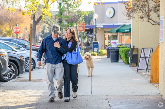 A couple enjoys a peaceful stroll through Claremont Village, soaking in the local charm.