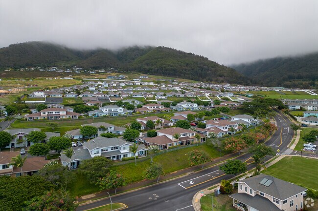 Homes in Wailuku sit beneath rolling mountains in an idyllic Hawaiian landscape.