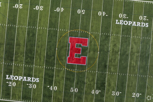 A green football field displays a red E for East High in Yalecrest.
