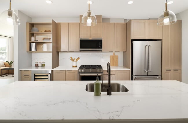 Signature Collection Kitchen with oak shaker cabinetry, marbled white quartz countertop and backsplash, and upgraded stainless steel appliances