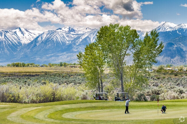 Golfers enjoy a round of golf with the Sierra Nevada Mountains as a stunning backdrop.