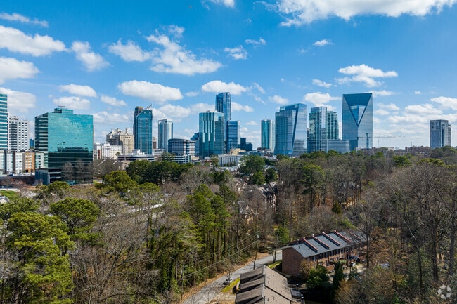 Tree-line homes sit close to the city in Buckhead Forest. 
with the skyline in the background.
