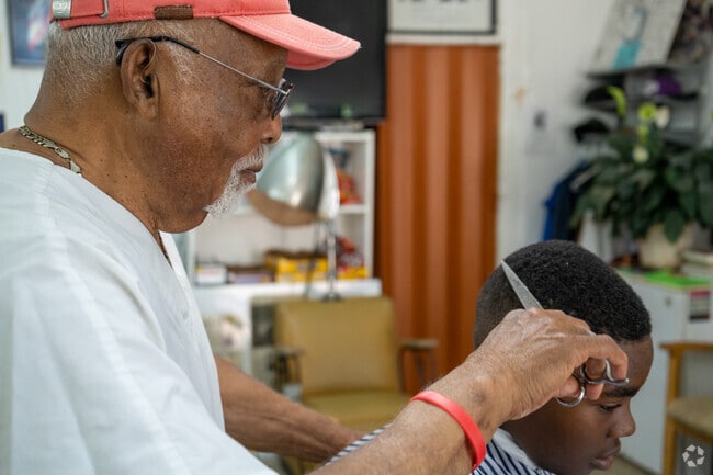 Vonzie Whitlow using the scissors given to him by Raymond Parks, Rosa Park's husband.