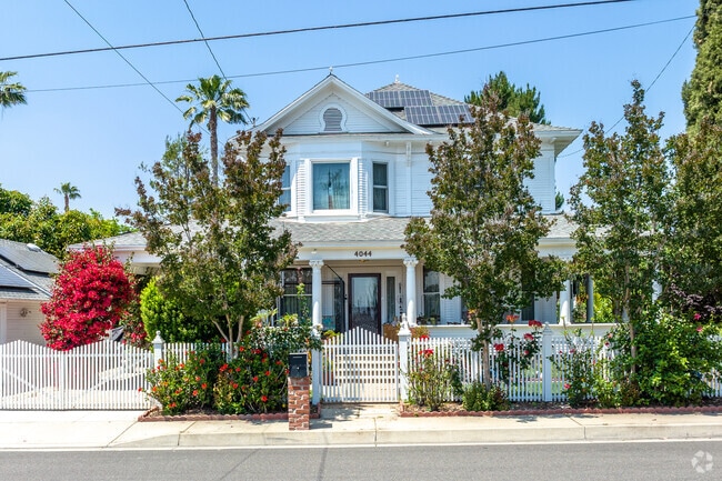 A stunning white Victorian-style home in Highland's Crossroads exudes timeless charm.