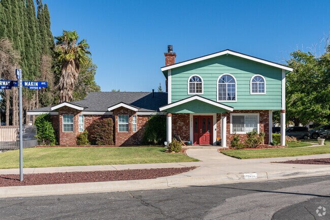 A colorful arts and crafts style home with a mixture of brick and wood siding in West Palmdale.