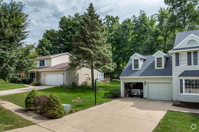 Many homes in Irvin Park feature maintained flower beds, planted bushes, and mature trees.