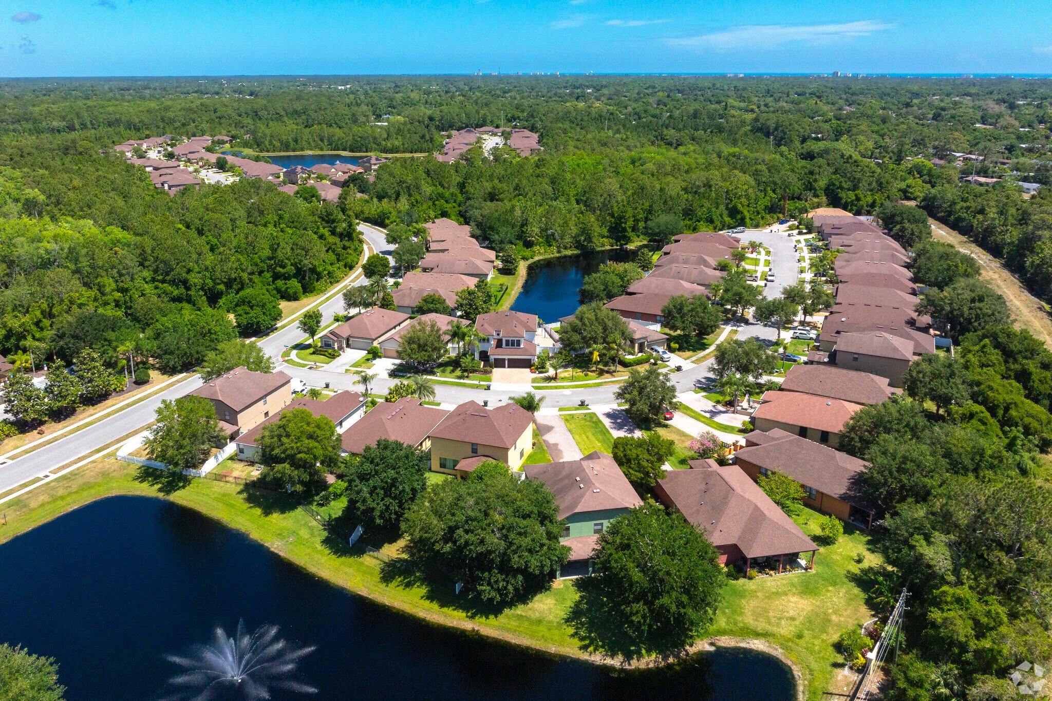 Tuscany Woods is a suburban community surrounded by lush foliage and water.