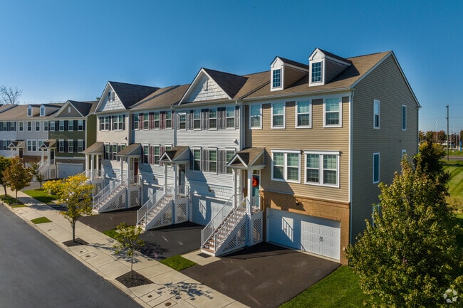 New construction townhomes in Warrington sit on sidewalk-lines streets  near major businesses.