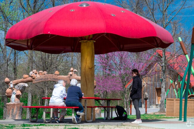Friends catch up under a toadstool shaped awning at Walker Mill Regional Park's playground.