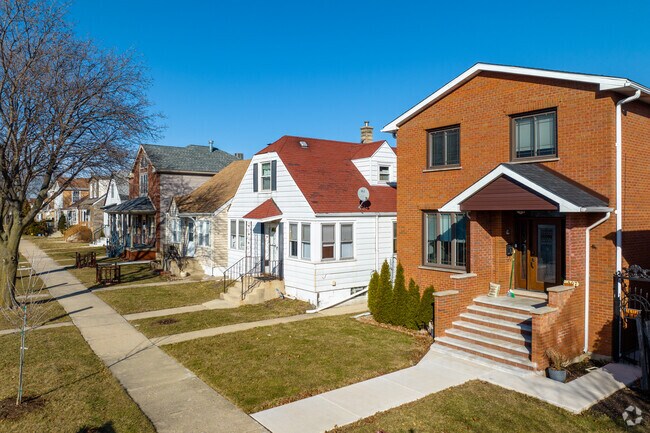 A row of charming homes in Harwood Heights, with brick exteriors, manicured lawns, and shaded streets.