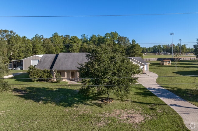 A one-story, Ranch-style home with a small warehouse and detached garage in Splendora.