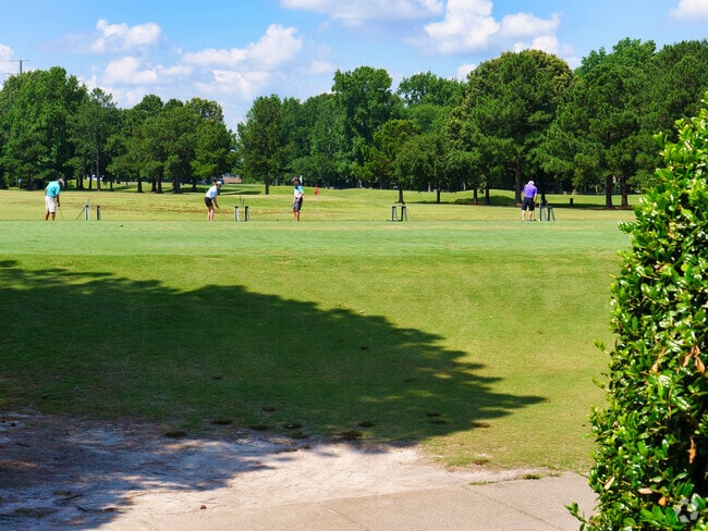 Ground view of golfers at driving range.