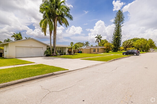 Tall palm trees line the sidewalks of Margate Gardens, offering shade and tropical charm.
