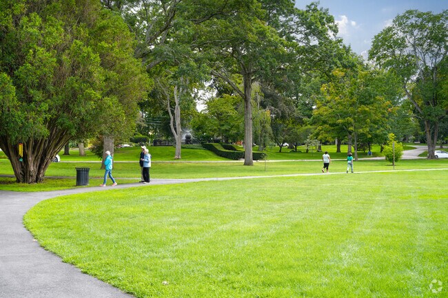 People walk along a trail beside green fields in Rehoboth.