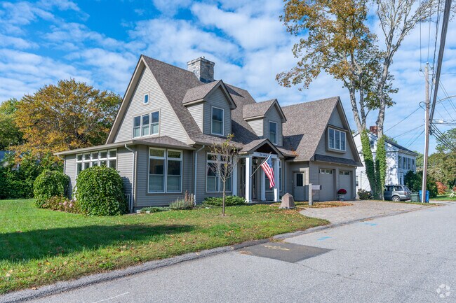 Modern home in Guilford with a manicured lawn and a calm ambiance in the background.