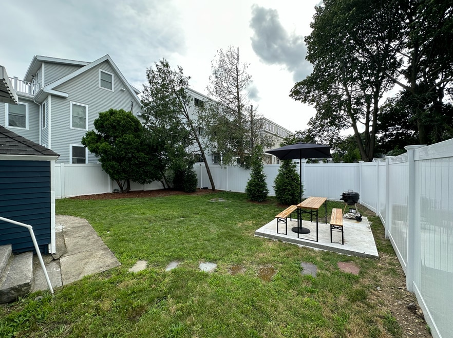 Professionally landscaped backyard with patio. Shared. White vinyl fence throughout.