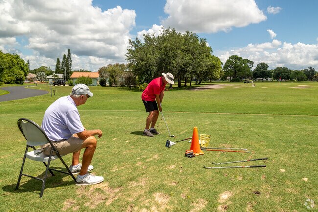 A Golf Hammock resident takes instruction on the driving range from the local golf pro.