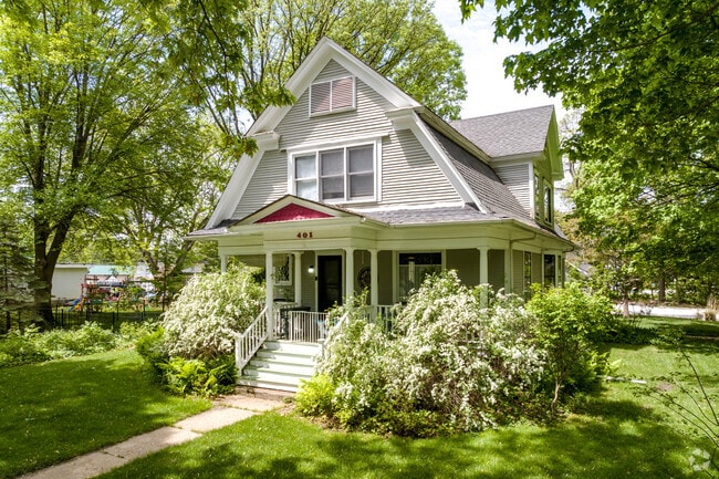 Colonial Revival style home with white columns and red scalloped siding located at Big Rock.