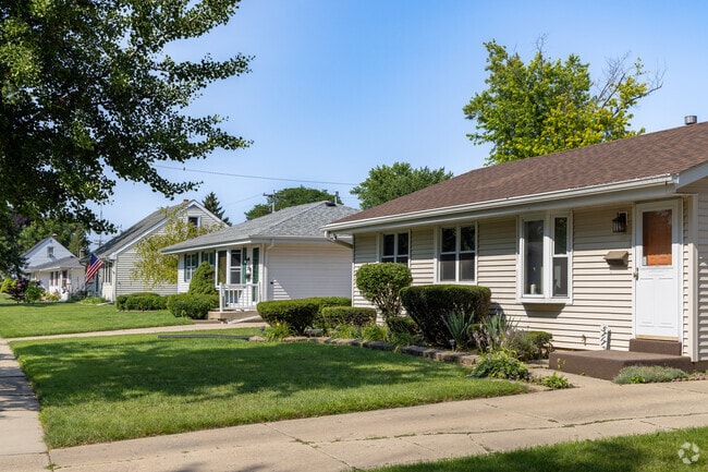 Most homes sit close together on manicured lawns with colorful gardens.