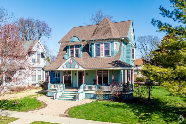 Colorful Victorian in Lords Park showcases ornate trim, turret roof, & bright turquoise facade.