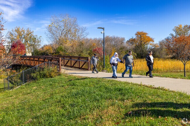 Kenosha locals walk across a bridge outside RecPlex at Prairie Spring Park during a Fall day.
