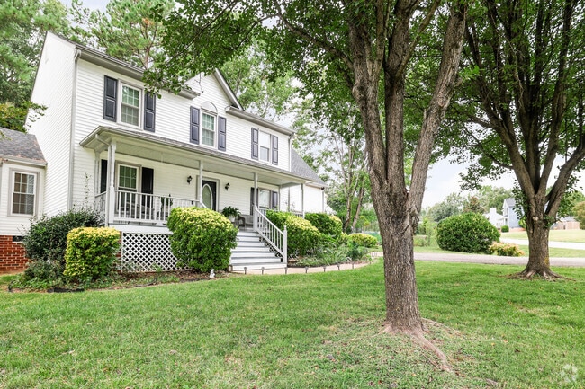 Iconic hardwood trees providing shade to a white home in Rockwood.