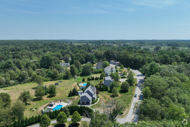 Greenland’s mix of forest, fields, and homes captured in a wide aerial landscape.