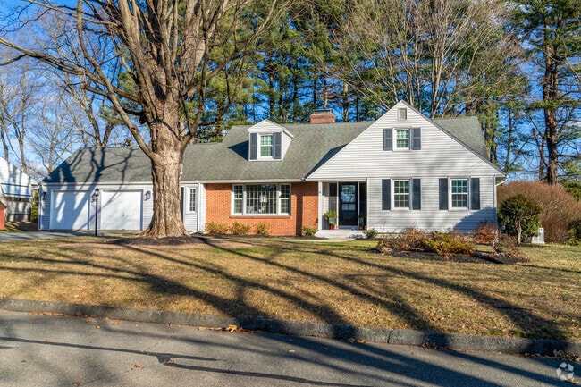 A minimal traditional style home in East Longmeadow features a brick and clapboard facade.