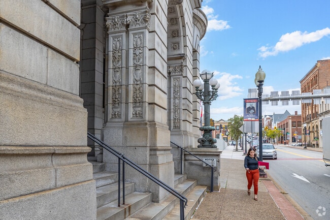 A resident walks down the street in Greensburg, among large historic architecture.