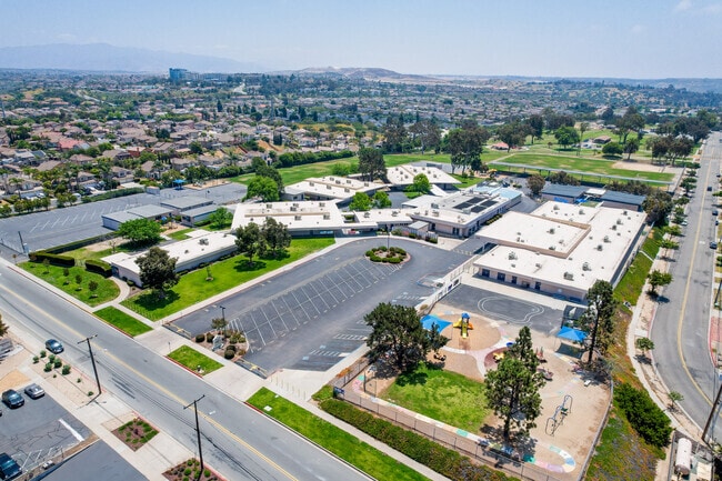 An Elevated view of Rogers Elementary shows student drop off at the entrance as well as playground and fields.