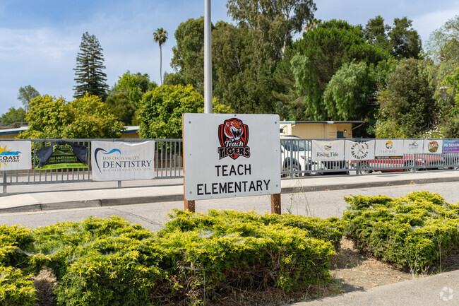 A small sign at the entrance of Teach Elementary School features the school mascot.