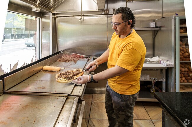 A proud cheesesteak chef shows off his latest creation to the Wynnefield lunch crowd.