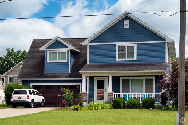 A new gable and wing home stands near the bustling Kalamazoo Farmers Market.