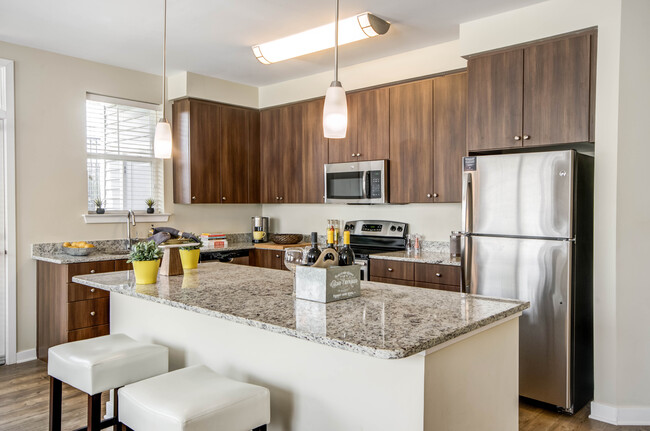 Two bedroom open concept kitchen with granite countertops, stainless-steel appliances, kitchen island and hard surface flooring