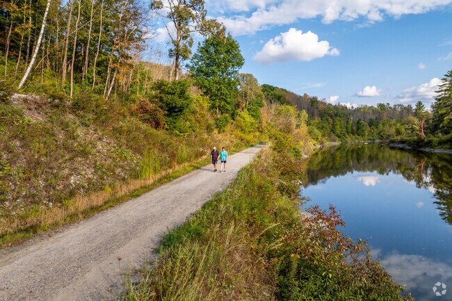 Folks walk along the Winooski River on the Montpelier VT Cross bike path near Northfield Street.