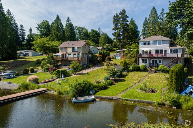 A row of large homes sit on the edge of Lake Morton.