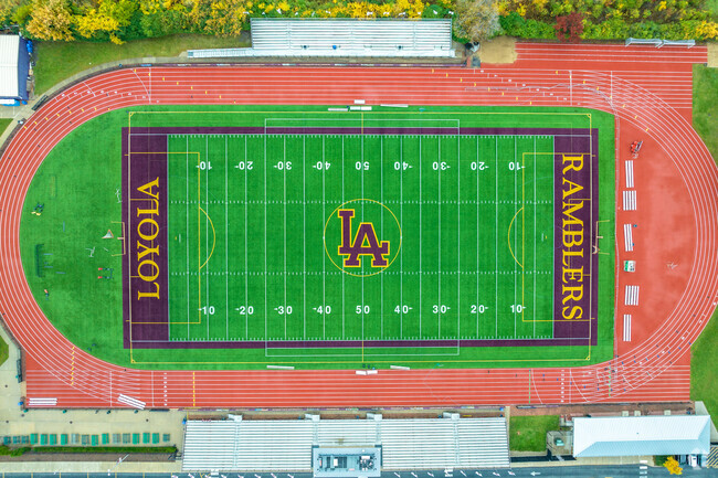 Loyola Academy Ramblers play on a beautiful field along the highway.
