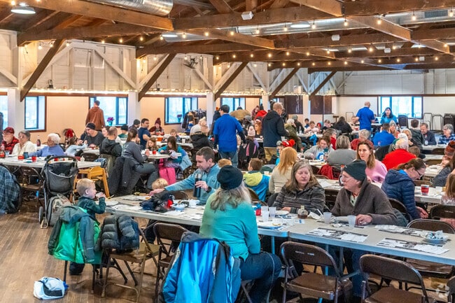 Families warm up and eat pancakes at the annual Pancake Toss Breakfast.