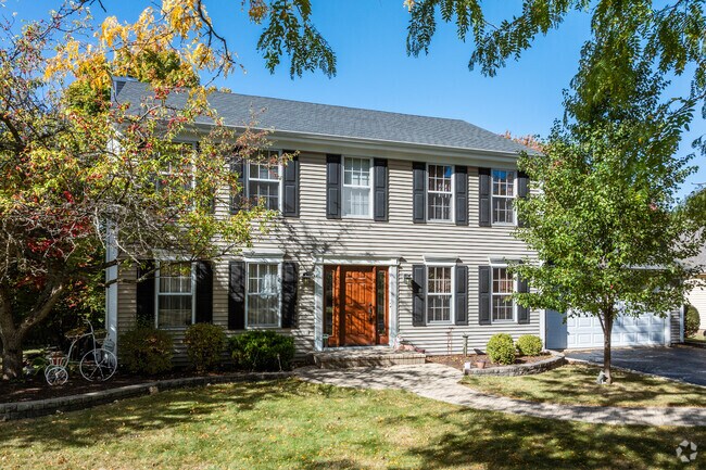 A Colonial Revival home in North Oswego is well shaded from the surrounding trees.