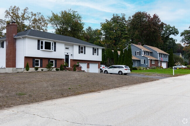 A white, brick split-level home in the quiet town of Hudson.